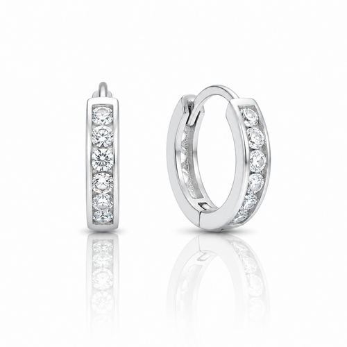 A pair of silver huggie hoop earrings with channel-set round clear gemstones, shown from the side and back on a reflective white surface.